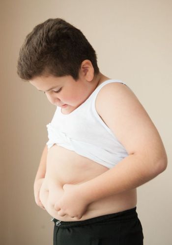 fat boy in a t-shirt holding his stomach fat boy in a t-shirt holding his stomach