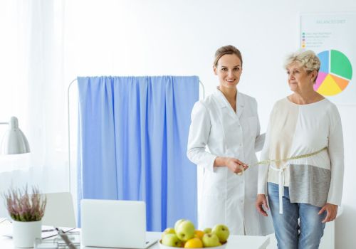 Smiling nutritionist measuring patient Smiling nutritionist measuring patient