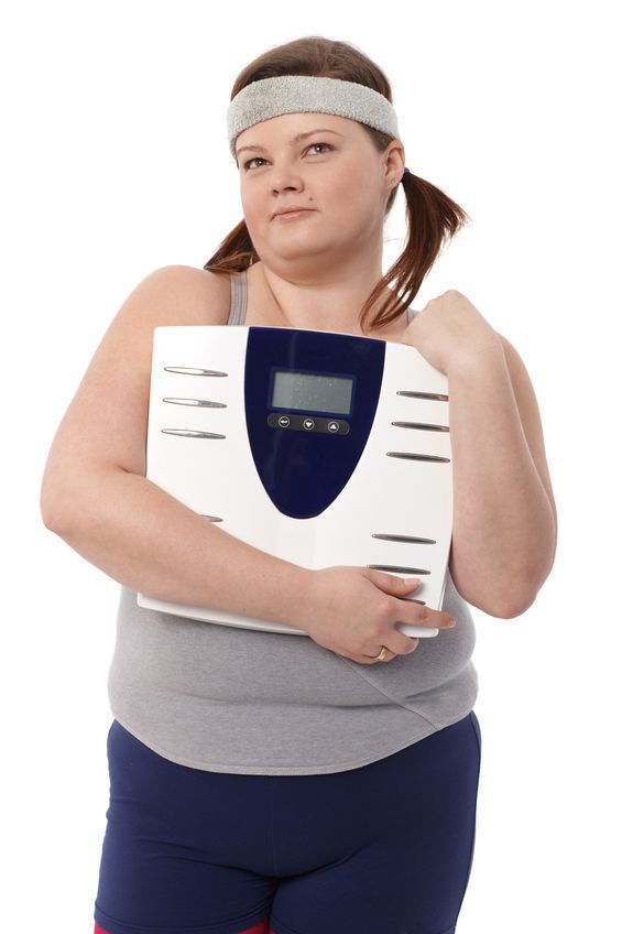 12472223 - fat woman in sportswear holding a scale in hands, daydreaming. fat woman in sportswear holding a scale in hands, daydreaming.
