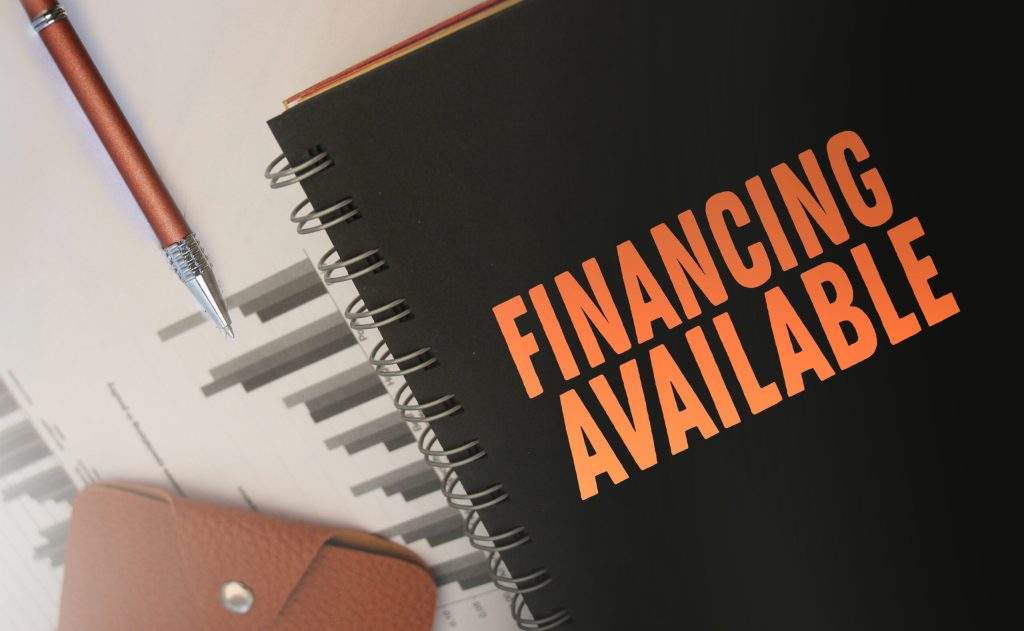Text financing available in copybook, financial report and brown leather wallet on wooden table. Business financial concept Text financing available in copybook, financial report and brown leather wallet on wooden table. Business financial concept