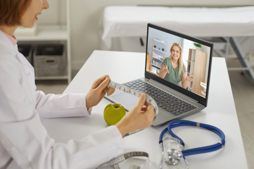 Smiling woman patient asking questions about slimming to woman doctor nutritiologist during online chat